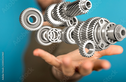 Hand holding gears, represe...