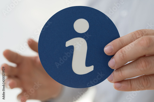 Man holding an information icon for assistance guidance and help