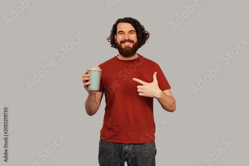White Man Holding Reusable Cup Pointing, Promoting Sustainable Habit, Ecofriendly Tumbler, Commuter Morning