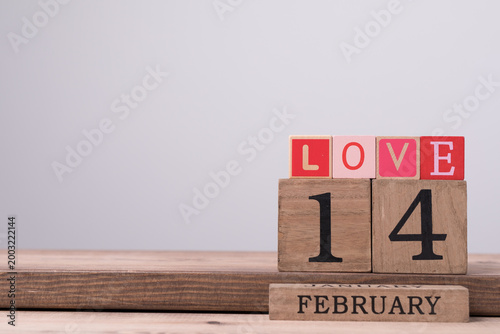 Wooden blocks spelling LOVE and displaying February fourteenth date celebrates love
