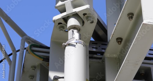 Close-up of a transformer bushing insulator mounted on high voltage electrical equipment. The image shows a structural connection point used for conducting electricity through grounded barriers. 