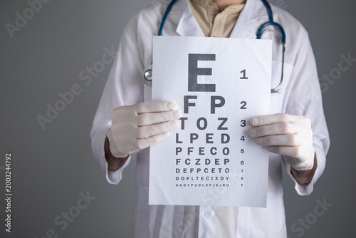 фотографія Caucasian doctor showing eye examination test.