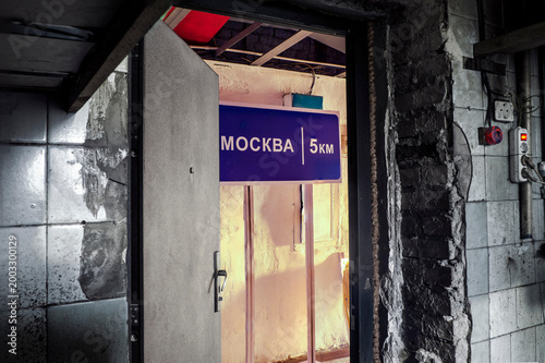 An abandoned corridor littered with garbage serves as a bright backdrop for the sign 