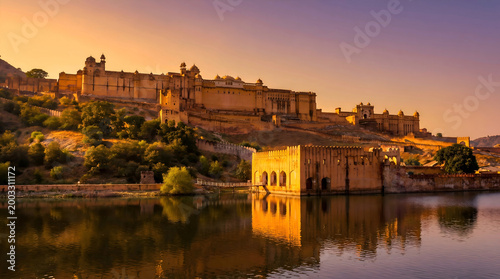Fotografie Amber fort reflected in lake at sunset with warm golden light