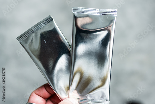 Playing cards collectible with a shiny foil plastic booster pack in hand