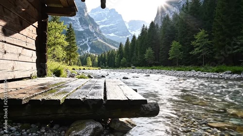 Wooden bridge over mountain river stream.