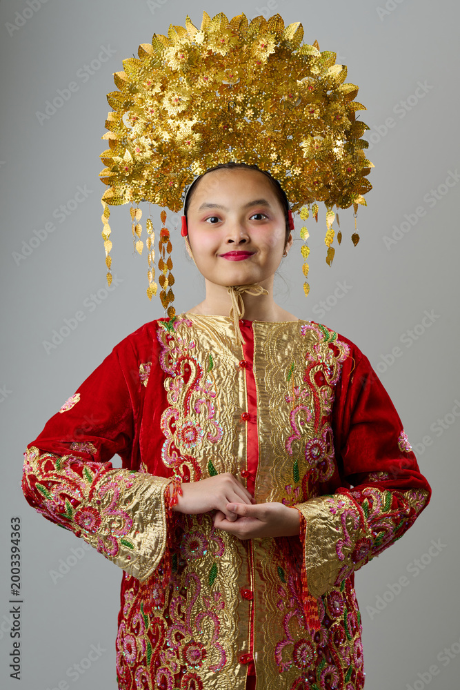 Fototapeta premium Traditional Headdress And Ornate Red Gold Costume Portrait Of A Young Indonesian Asian Girl For Festival Or Ceremony