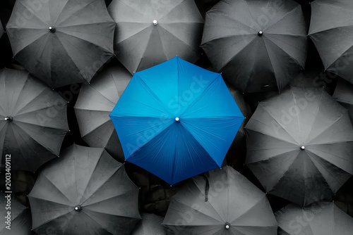 Blue Umbrella Standing Out Among Gray Umbrellas – Symbol of Innovation and Leadership