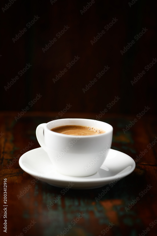 Fototapeta premium Cup of coffee on rustic wooden background. Soft focus. Copy space