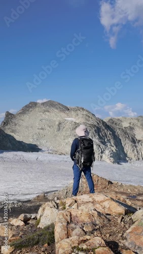 Hiker Admiring Majestic Glacier and Mountain Landscape in British Columbia, Canada on a Sunny Day