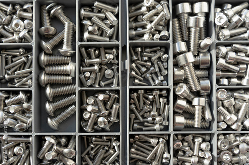 Photos Metal fasteners organized in box compartments, industrial background pattern