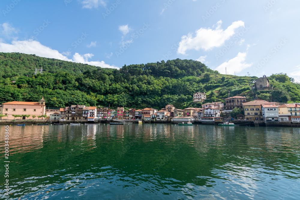 Fototapeta premium Traditional colorful houses reflected in the water at Pasai Donibane harbor in the Basque Country near San Sebastian, Spain.