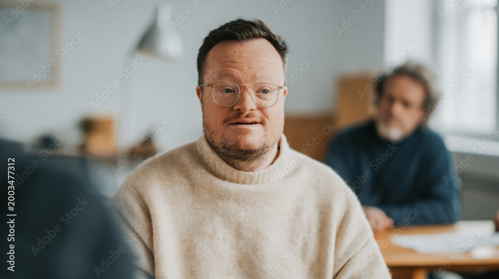 Fototapeta premium Two Men Having a Business Meeting with a Colleague with Down Syndrome Listening Attentively in a Modern Bright Office Space