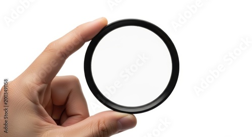 Camera lens filter held by a hand against white background