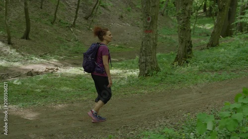 Woman hiking up forest slope
