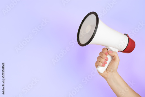 Hand holding megaphone on pastel background – communication concept