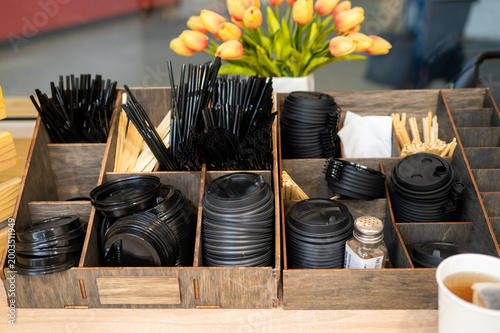 Coffee shop self service station with plastic lids straws and tulips