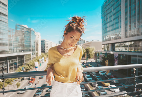 young woman standing on her balcony in the city