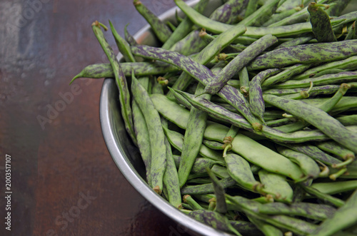 Fresh green string beans with purple stripes close-up. Raw, organic flat string beans. Raw vegetables from the garden.