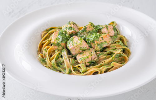 Whole grain tagliatelle pasta with salmon spinach in creamy sauce gourmet dish