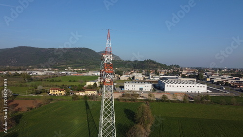 High-voltage electricity pylon in a rural landscape with industrial area