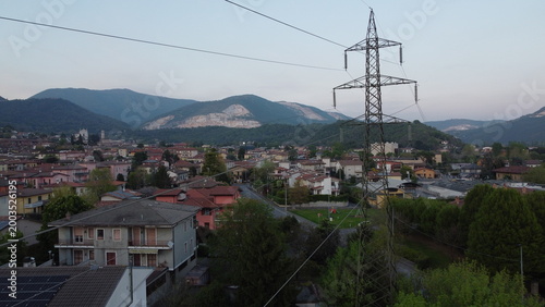 High-voltage electricity pylon in a rural landscape with industrial area