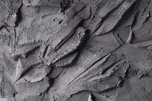 Close-up of rough gray cement or plaster surface with irregular strokes and patterns, creating a textured abstract background b.vv