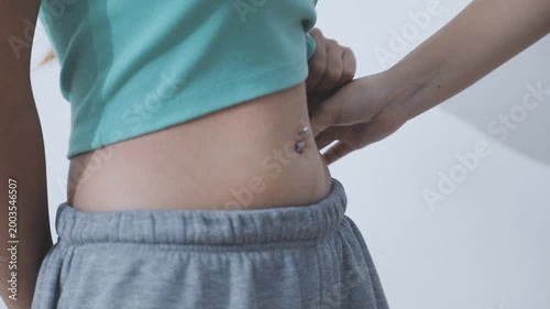Overweight woman body with hands touching belly fat