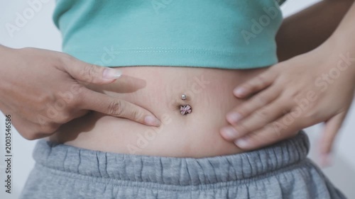Overweight woman body with hands touching belly fat