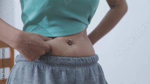 Overweight woman body with hands touching belly fat