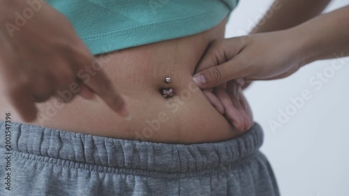 Overweight woman body with hands touching belly fat