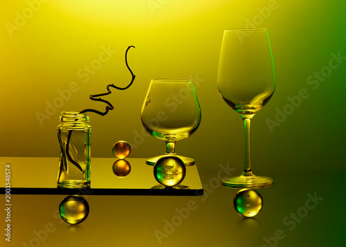 Art-photo with glasses ,balls and bottles with branch