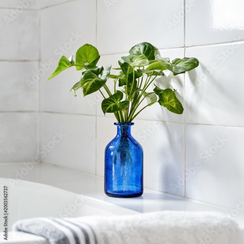 Blue Vase With Green Plant Placed Near Towel in Bathroom Setting