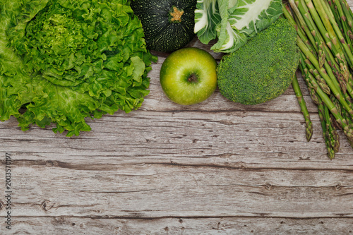 Fresh Green Vegetables and Apple Border on Rustic Wooden Background with Copy Space