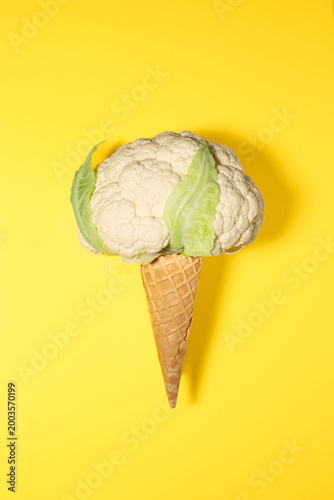 Conceptual Cauliflower Ice Cream Cone on Vibrant Yellow Background