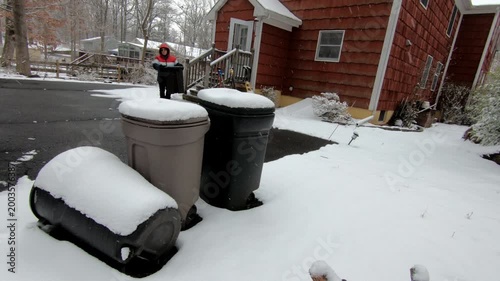 woman emptying the trash in the backyard after the snow storm in February