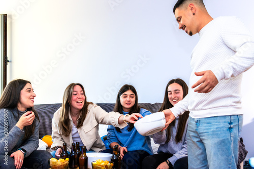 Friends enjoying snacks while watching a sports match together at home