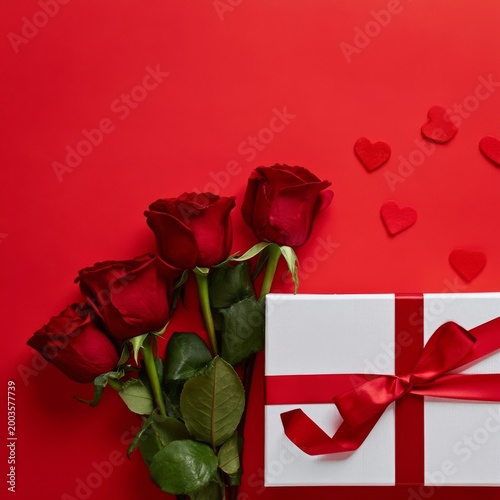 Gift Box and Red Roses With Heart Shapes on Red Background for Special Occasi...