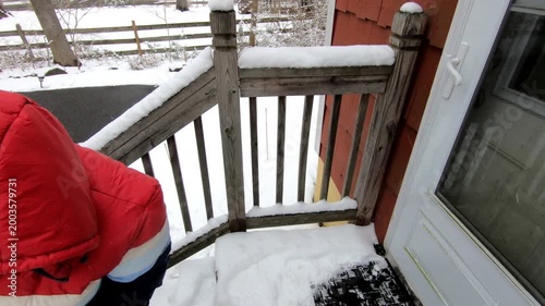 woman shoveling the snow from the stairs after the snow storm in February