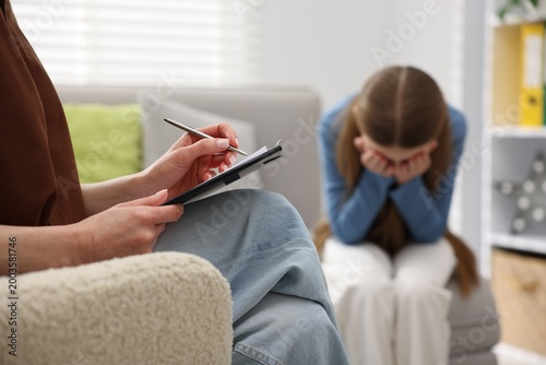 Schilderij op canvas Professional child psychologist working with upset girl and writing in clipboard
