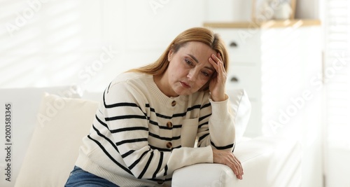 Quadro su tela Menopause. Woman suffering from headache on sofa at home
