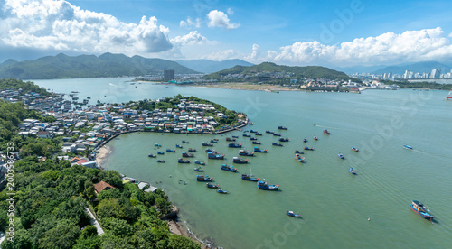 Bild auf Leinwand An aerial view of a coastal village in Hon Mieu, Nha Trang, Vietnam, with numerous fishing boats docked in the turquoise bay