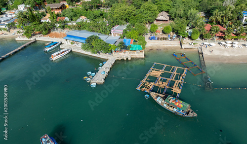 Fotografie Workers construct a floating platform near a pier with boats in Hon Mieu, Nha Trang, Vietnam