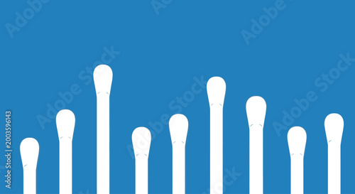 Row of white cotton swabs on a blue background, hygiene and cleanliness concept