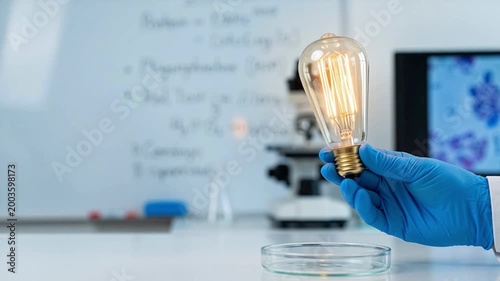 Scientist Holding Light Bulb while Working with Petri Dish in Laboratory Setting