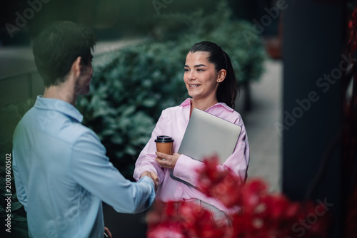 Cuadro en lienzo Businesswoman and businessman shaking hands, sealing a partnership deal or greet
