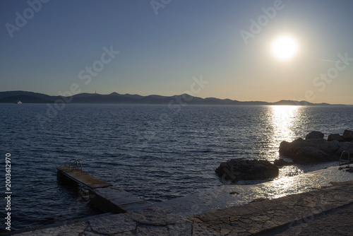 Golden sunset over the Adriatic Sea with a concrete pier in Croatia