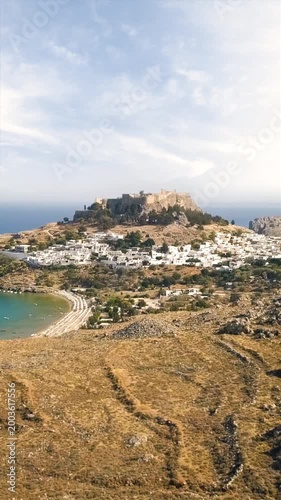 Aerial View of Lindos Village with Ancient Acropolis and Mediterranean Coastline. Vertical video