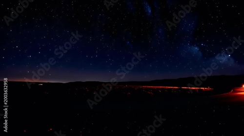 Long exposure captures a rural highway illuminated by speeding headlights under a vibrant starry night sky evoking feelings of travel adventure and boundless possibility