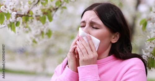 Woman suffering from seasonal allergy in park on spring day